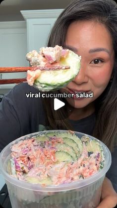 a woman holding up a container with food in it