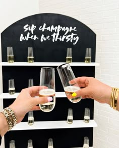 two people are toasting with wine glasses in front of a sign that says self champagne while we thirsty