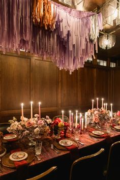 a long table with plates and candles on it