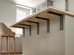 a kitchen with an island and bar stools in the middle, next to a counter