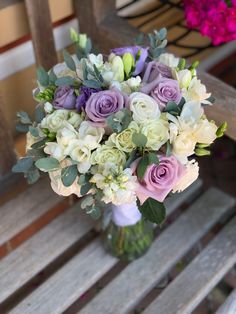 a bouquet of flowers sitting on top of a wooden bench