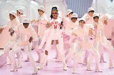 a group of young people standing on top of a pink floor next to each other