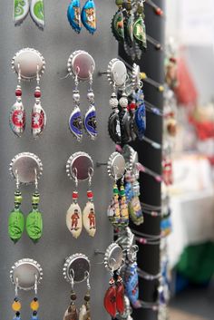 many different earrings are hanging on a wall