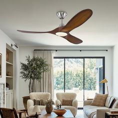 a living room with couches, chairs and a ceiling fan in the middle of it