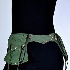 a woman wearing a green leather belt with gold studs