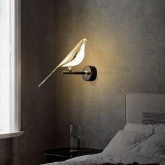 a white bird is sitting on the wall light