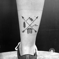 a person's foot with an arrow and car tattoo on the left side of their leg