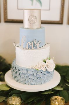 a blue and white wedding cake sitting on top of a table