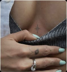 a woman's hand with a cross tattoo on her left side ring and finger