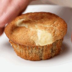 a close up of a muffin on a plate with butter and cheese in it