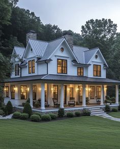 a large white house with lots of windows on it's roof and front porch