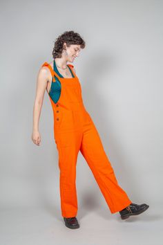 WOW!  These brilliant orange dungarees are so orange they are nearly neon! You will really stand out in these! These are so comfy and will look amazing on you, the shape is flattering and they are just so comfy to wear.  100% woven cotton making them durable as well as comfy. They hang really well and are just beautiful with lots of pockets and button detail. Desgined by me and made by my friend in Pushkar who is paid a living wage as set by him for his work.  Avalible in multiple sizes and lots Orange Dungarees Outfit, Summer Orange Cotton Jumpsuits And Rompers, Yellow And Orange Outfit, Orange Workwear Bottoms With Pockets, Jail Jumpsuit Orange, Orange Dungarees, Playful Orange Cotton Onesie, 20 Weeks Pregnant, Colorful Jumpsuit