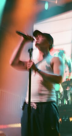 a man standing in front of a microphone on stage