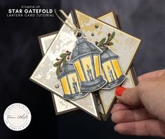 a hand holding a card with two yellow lanterns on it and the words, star caterfold lantern card tutorial written below