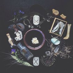 an assortment of items are arranged on a black tablecloth, including candles and pictures