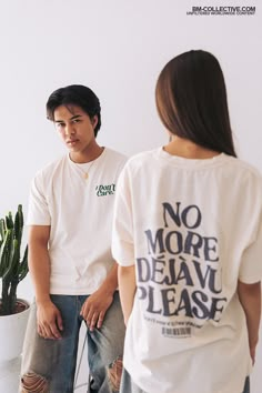 two people standing next to each other in front of a potted plant and wearing t - shirts that say no more deja vuve please