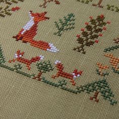 a cross stitch pattern with deers and trees