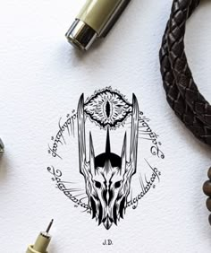 a pen and some other items on a white paper with black ink, including an owl's head