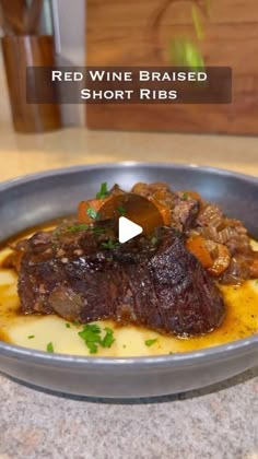 red wine raised short ribs served in a silver bowl on a marble counter top with parsley garnish