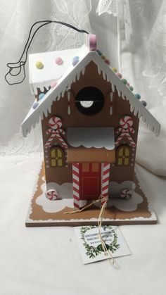 a gingerbread house made out of cardboard with candy canes on the roof and door