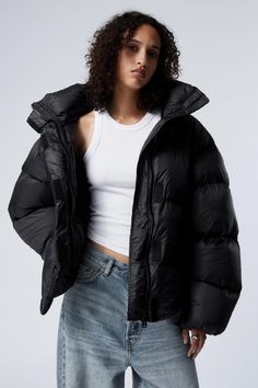 An oversized nylon puffer jacket crafted from a soft recycled polyamide, padded with recycled down for ultimate warmth. This go-to puffer features a stand collar, a sturdy versatile 2-way zipper, Velcro placket, roomy side seam pockets, and two inner pockets. Oversized Nylon Puffer Jacket For Streetwear, Oversized Black Puffer Jacket, Oversized Cotton Puffer Jacket, Oversized Nylon Puffer Jacket With Pockets, Oversized Winter Puffer Jacket With Double-lined Hood, Oversized Puffer Jacket, Oversized Puffer, Black Puffer Jacket, Black Down