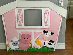 a pink barn with farm animals painted on it