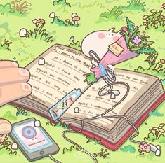 an open book sitting on top of a lush green field next to a cell phone