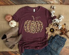 a t - shirt that says happy on it next to some flowers and denim jeans