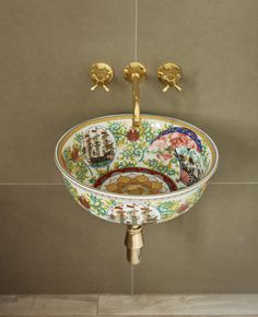 an ornate sink with golden faucets and decorative designs