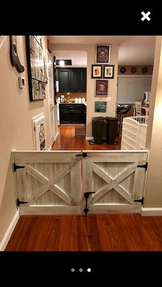 an open door leading to a kitchen and living room with pictures on the wall behind it