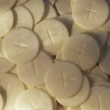 a pile of white cookies with crosses on them