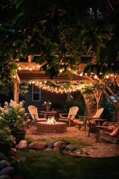 an outdoor fire pit surrounded by chairs and lights