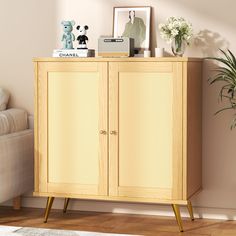 a wooden cabinet sitting next to a couch in a living room with a potted plant on top of it