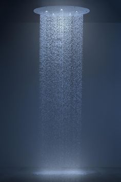 a shower head with water running down it's side and the light shining on top