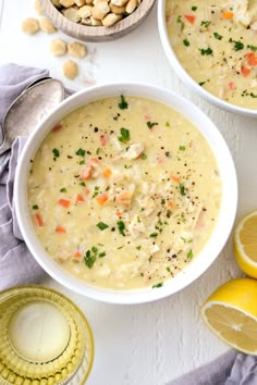 two bowls filled with soup next to lemon slices