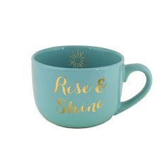 a blue mug with gold lettering on the side and a sun in the middle that says rise & shine