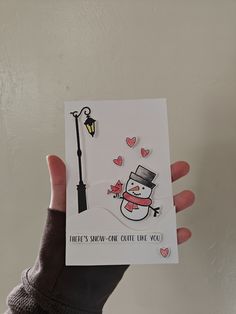 someone holding up a card with a snowman on it