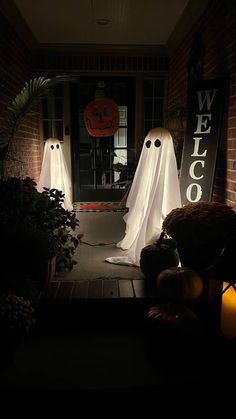 halloween decorations on the front door of a house with ghost and pumpkins lit up