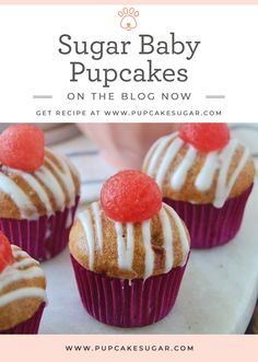 some cupcakes with white frosting and red cherries on top are sitting on a plate