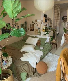 a bedroom with green bedding and plants in the corner