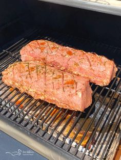 two steaks are cooking on the grill