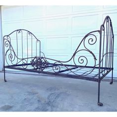 a wrought iron bed frame in front of a garage door