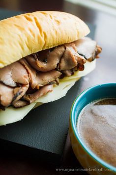 a close up of a sandwich on a plate near a cup of coffee