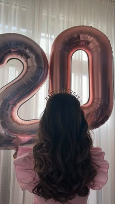 the back of a woman's head with large balloons in front of her