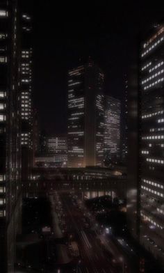 cityscape at night with cars and buildings in the foreground