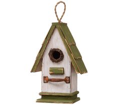 a white birdhouse with a green roof