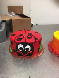 two cakes decorated to look like ladybugs are sitting on a table next to each other