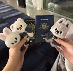 two stuffed animals are being held next to an australian passport and someone is holding it