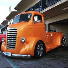 an orange truck parked in front of a building