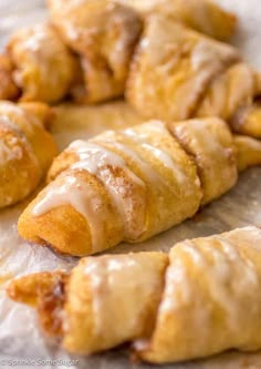 several pastries sitting on top of a piece of wax paper covered in icing